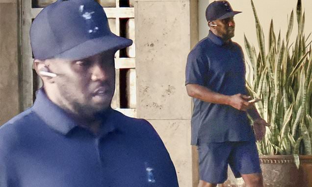 Diddy takes a call at his mansion - after double raids on his homes