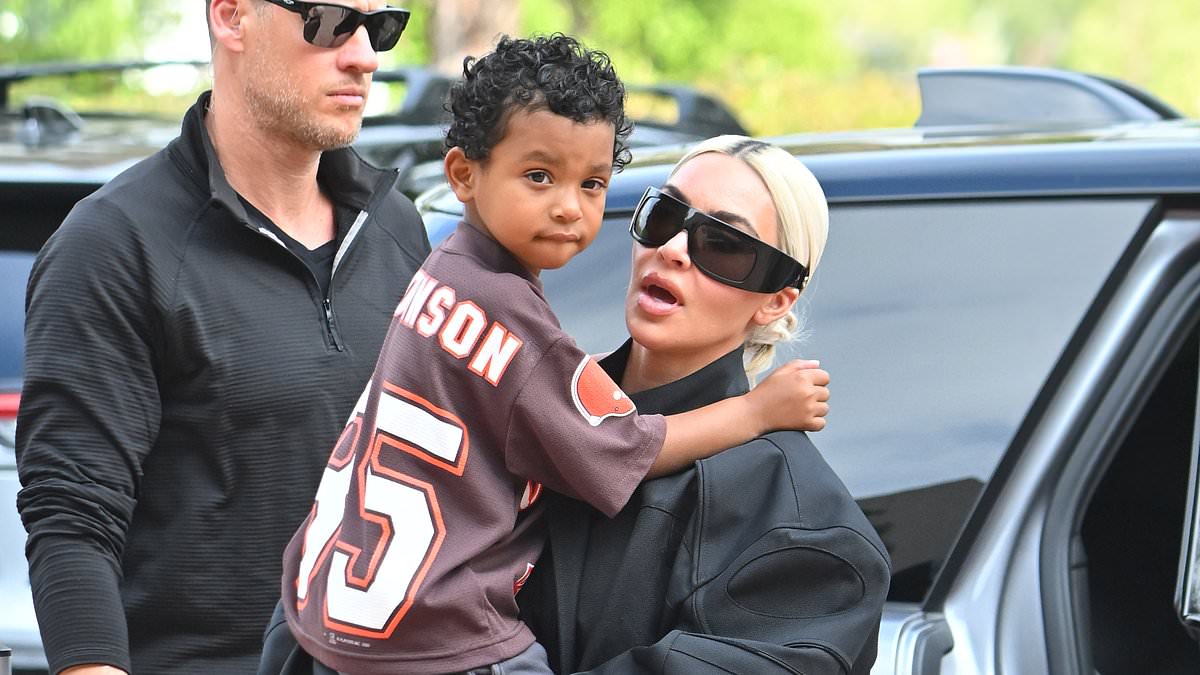 Kim Kardashian covers her curves in a baggy black outfit as she carries her son Psalm days before his 5th birthday